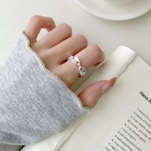 Sterling silver ring with interconnected oval links, delicate chain link design.
