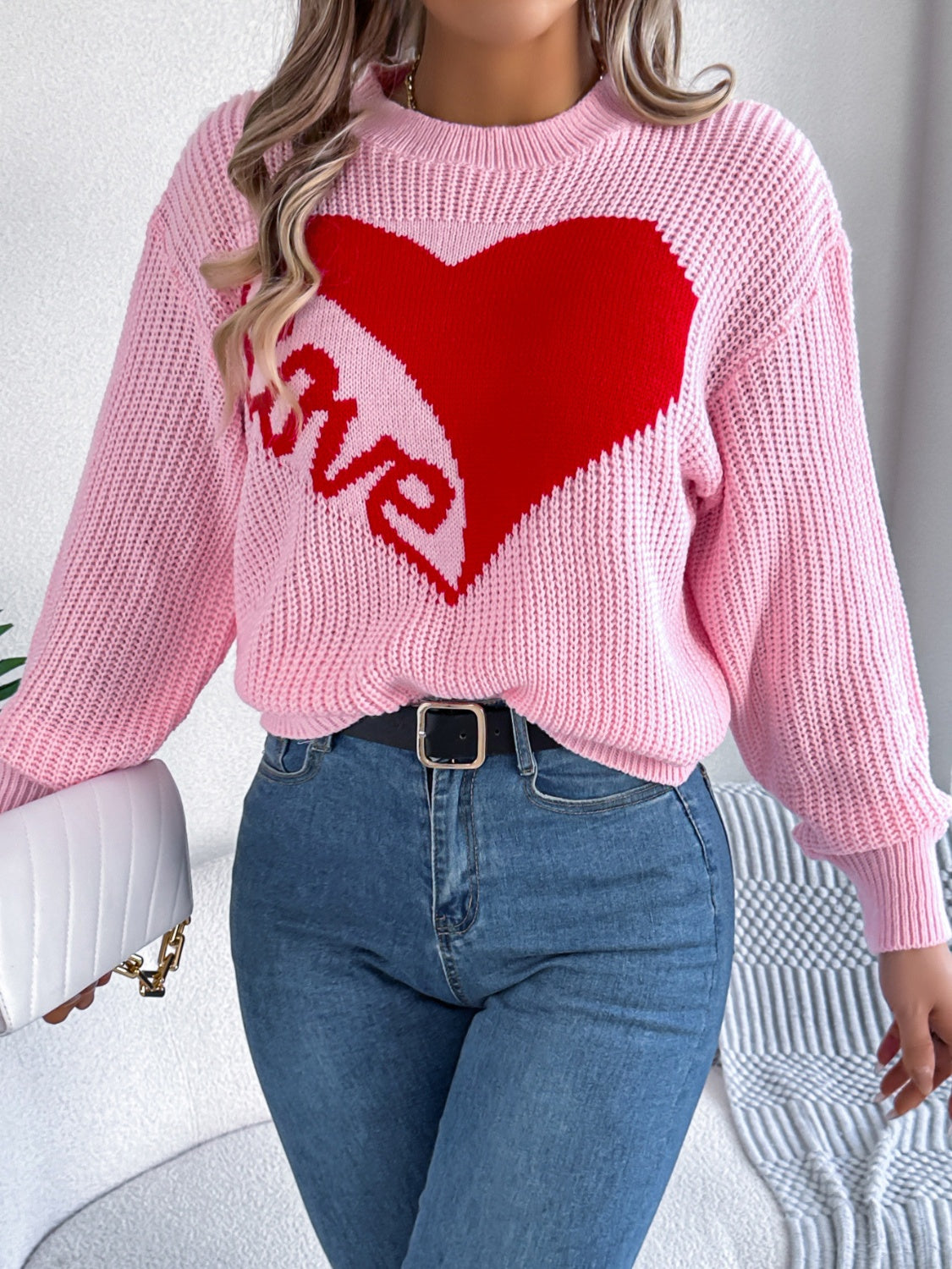 Pink knit sweater with red heart and love graphic, crewneck, long sleeves.
