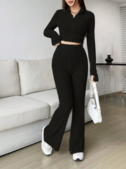 Black ribbed knit flare co-ord set with zip-neck crop top and high-waisted flared pants.
