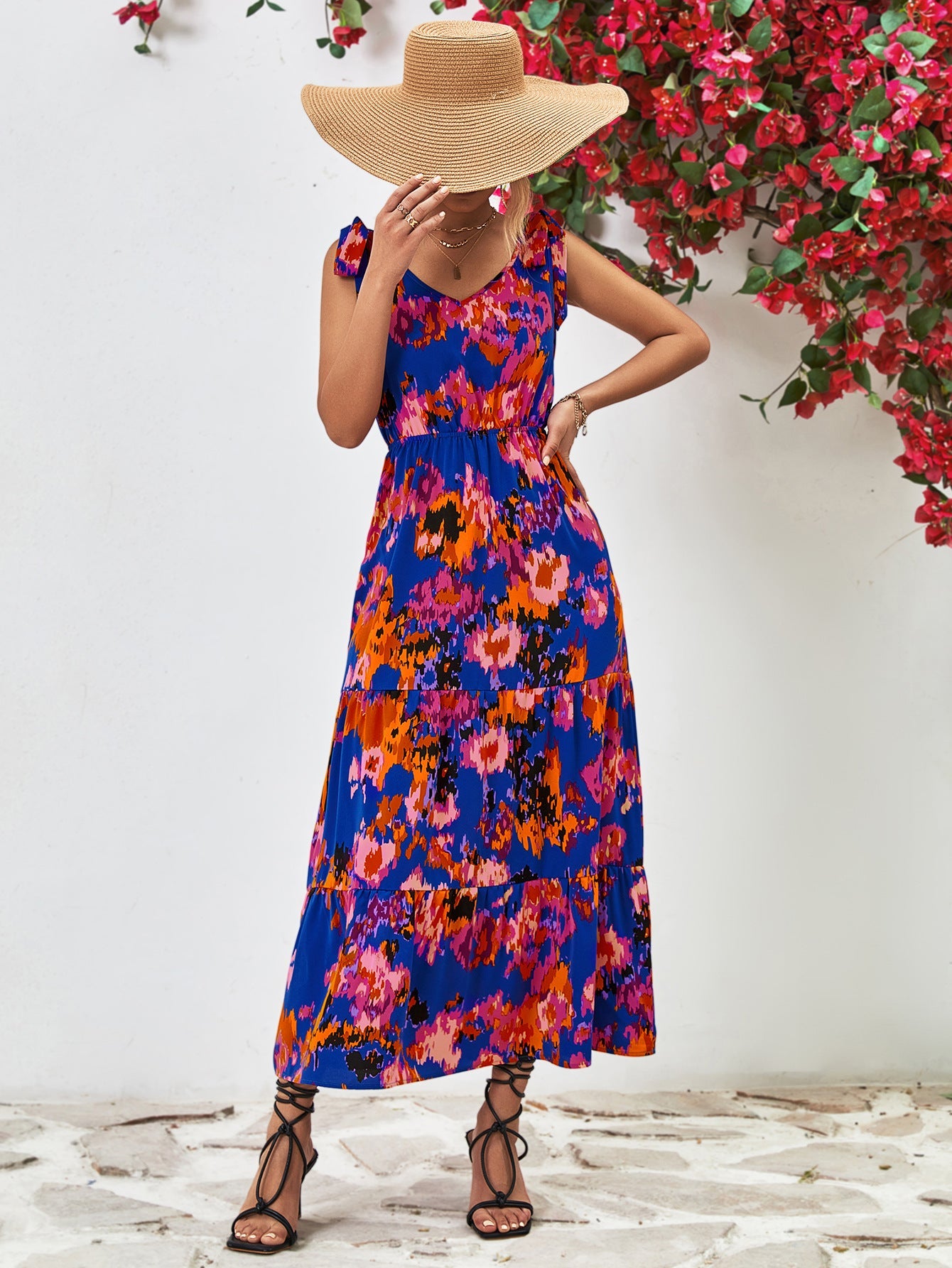 Maxi dress in dark blue with abstract print, tie straps, and tiered skirt.