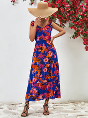 Maxi dress in dark blue with abstract print, tie straps, and tiered skirt.