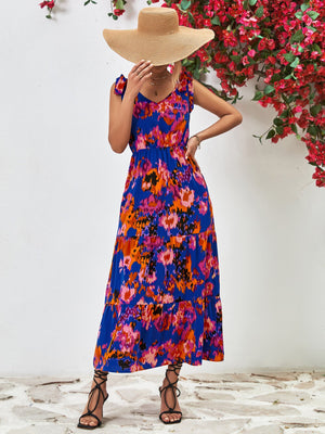 Maxi dress in dark blue with abstract print, tie straps, and tiered skirt.