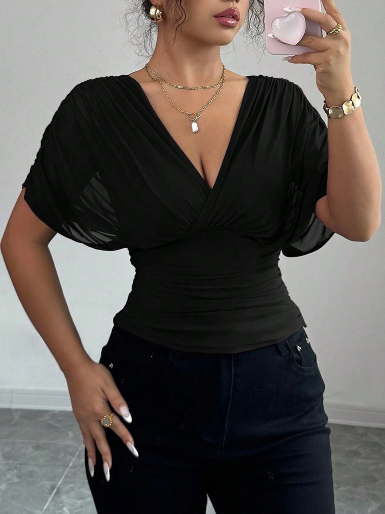 Black ruched surplice dolman sleeve top with deep V-neck.