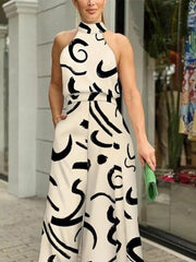 White halter neck romper with black abstract print and wide legs.