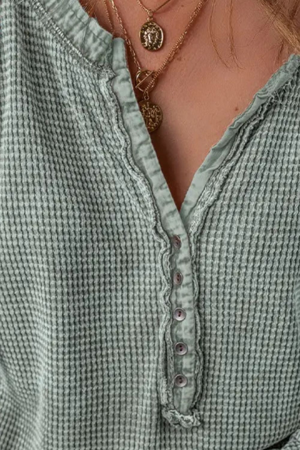 Sage waffle knit henley blouse with button detail and ruffled placket.