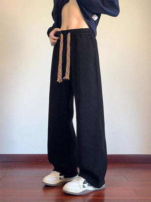 Men's black textured wide leg sweatpants with colorful drawstring detail.