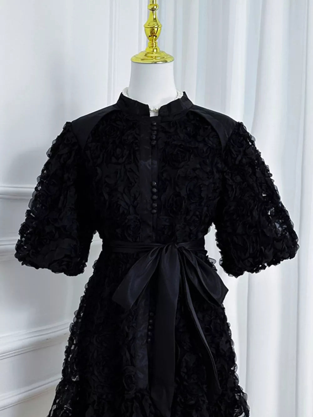 Black floral puff sleeve dress with button-down front and sash tie waist.