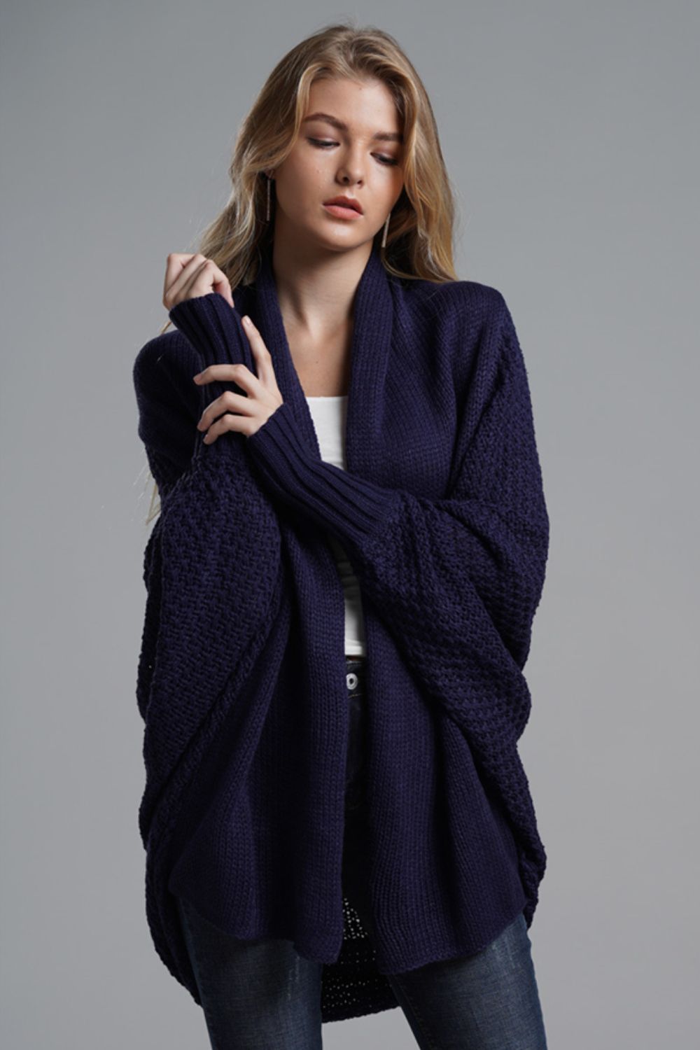 Navy batwing knit cardigan with drape front and textured sleeves.