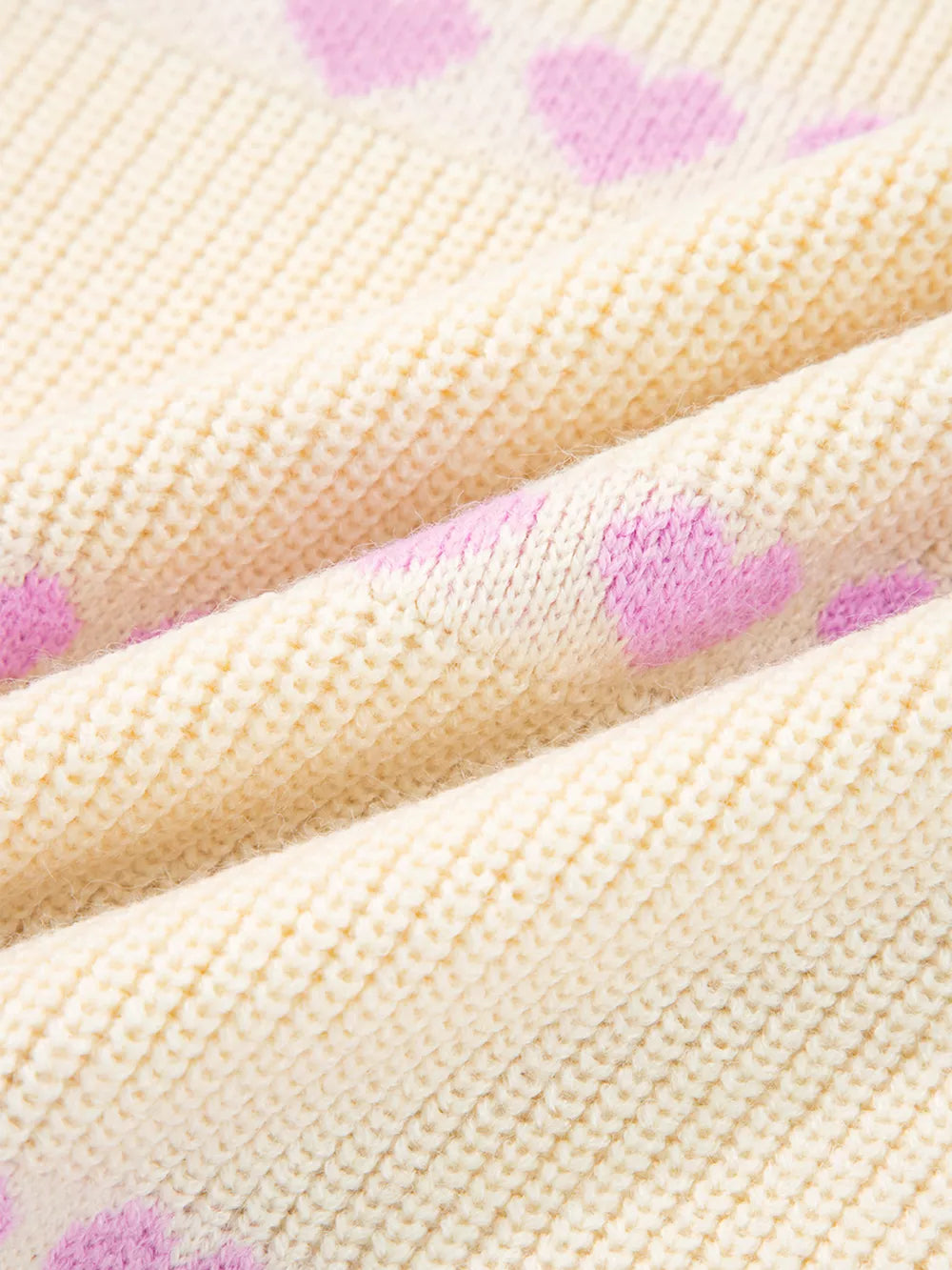 Cream knit sweater with pink heart pattern, acrylic blend fabric detail