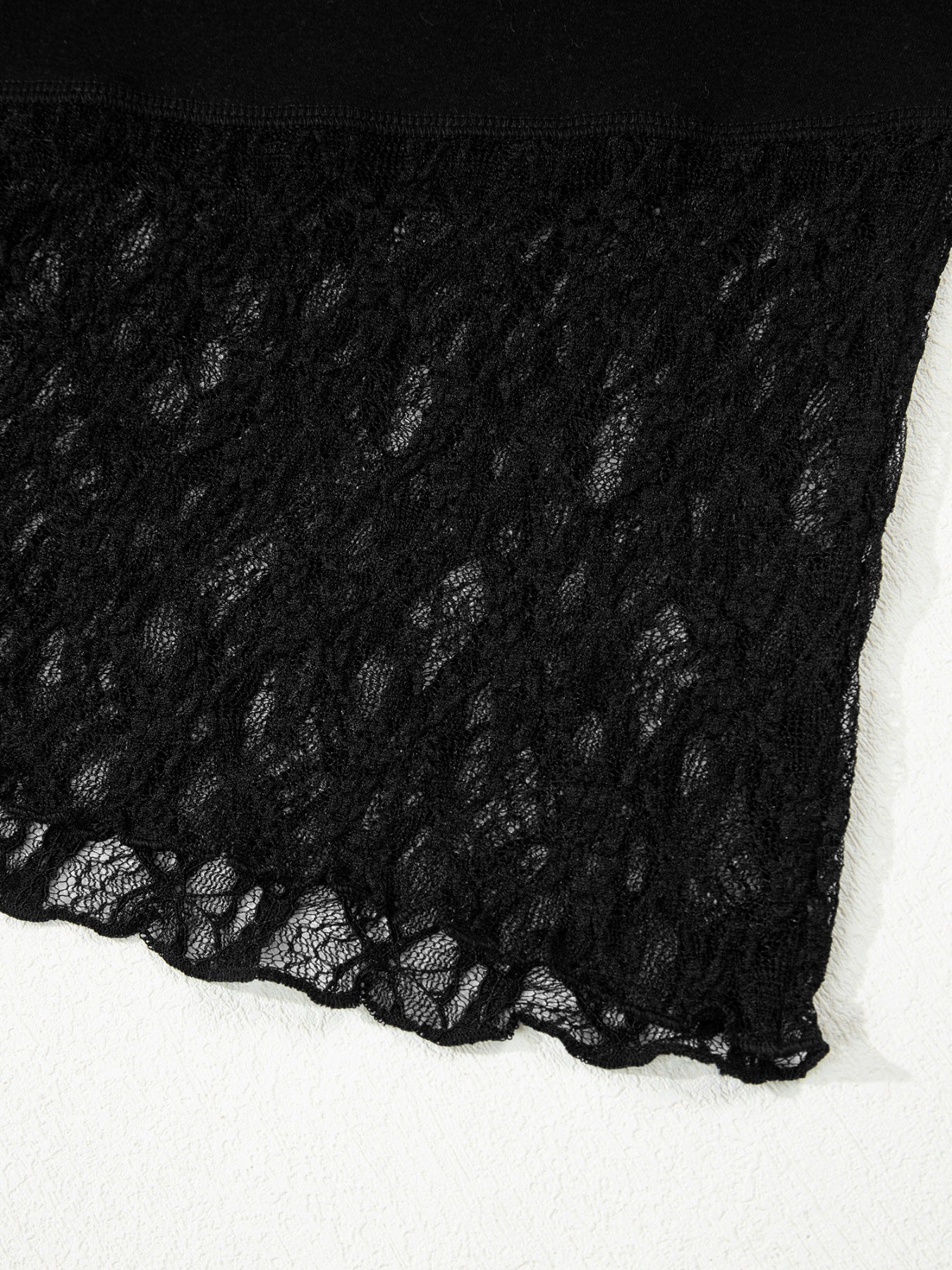 Black lace-trimmed asymmetric sheer shirt with scalloped hem detail.