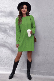 Green cable knit sweater dress with crew neck and long sleeves.