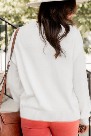 White drop shoulder sweater with ribbed cuffs and hem, styled with coral pants and a crossbody bag.