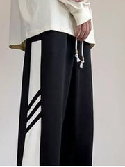 Men's black relaxed fit sweatpants with white contrast stripe detail and drawstring.