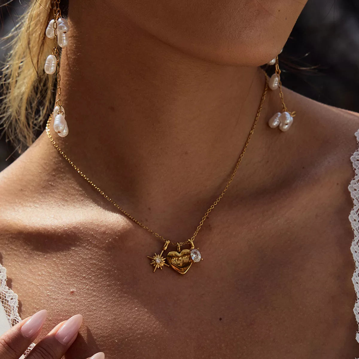Gold heart charm necklace with MOM engraving and celestial details.