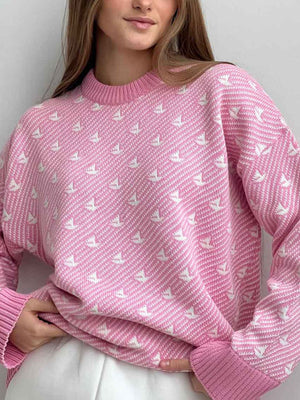 Blush pink knit sweater with all-over white sailboat jacquard pattern and ribbed crewneck.