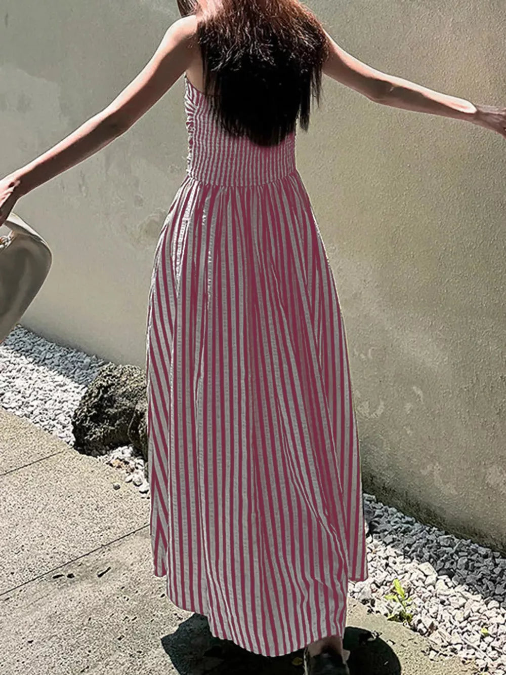 Pink striped maxi dress with smocked bodice and side slit.