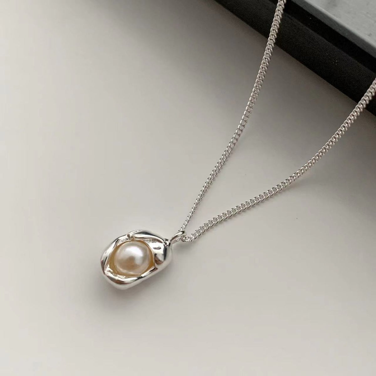 Sterling silver pendant necklace with a single pearl, delicate chain.