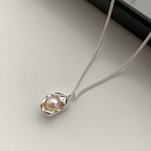 Sterling silver pendant necklace with a single pearl, delicate chain.