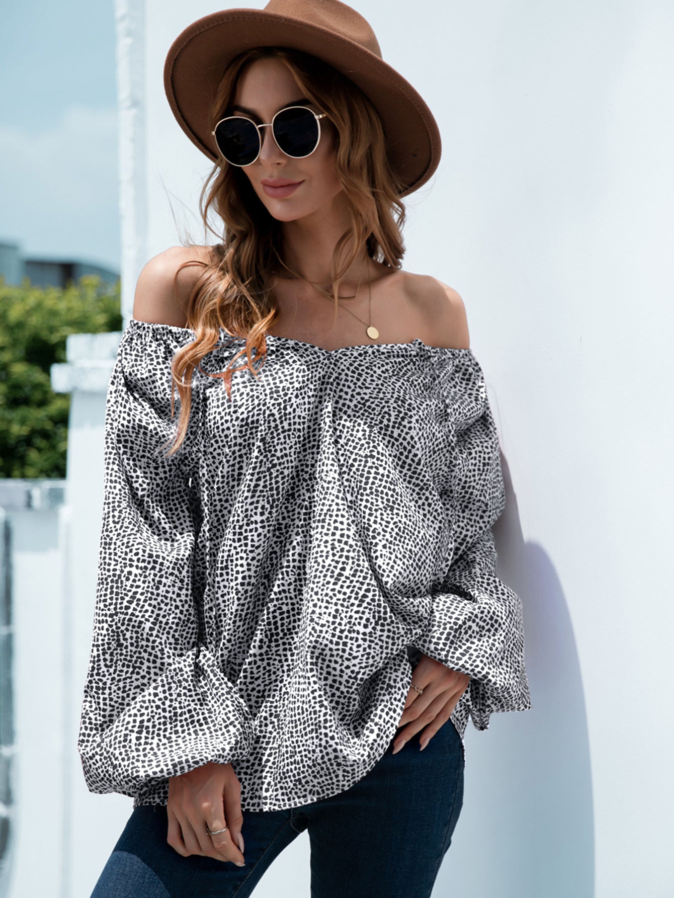 Off-the-shoulder black spotted print blouson top with balloon sleeves.