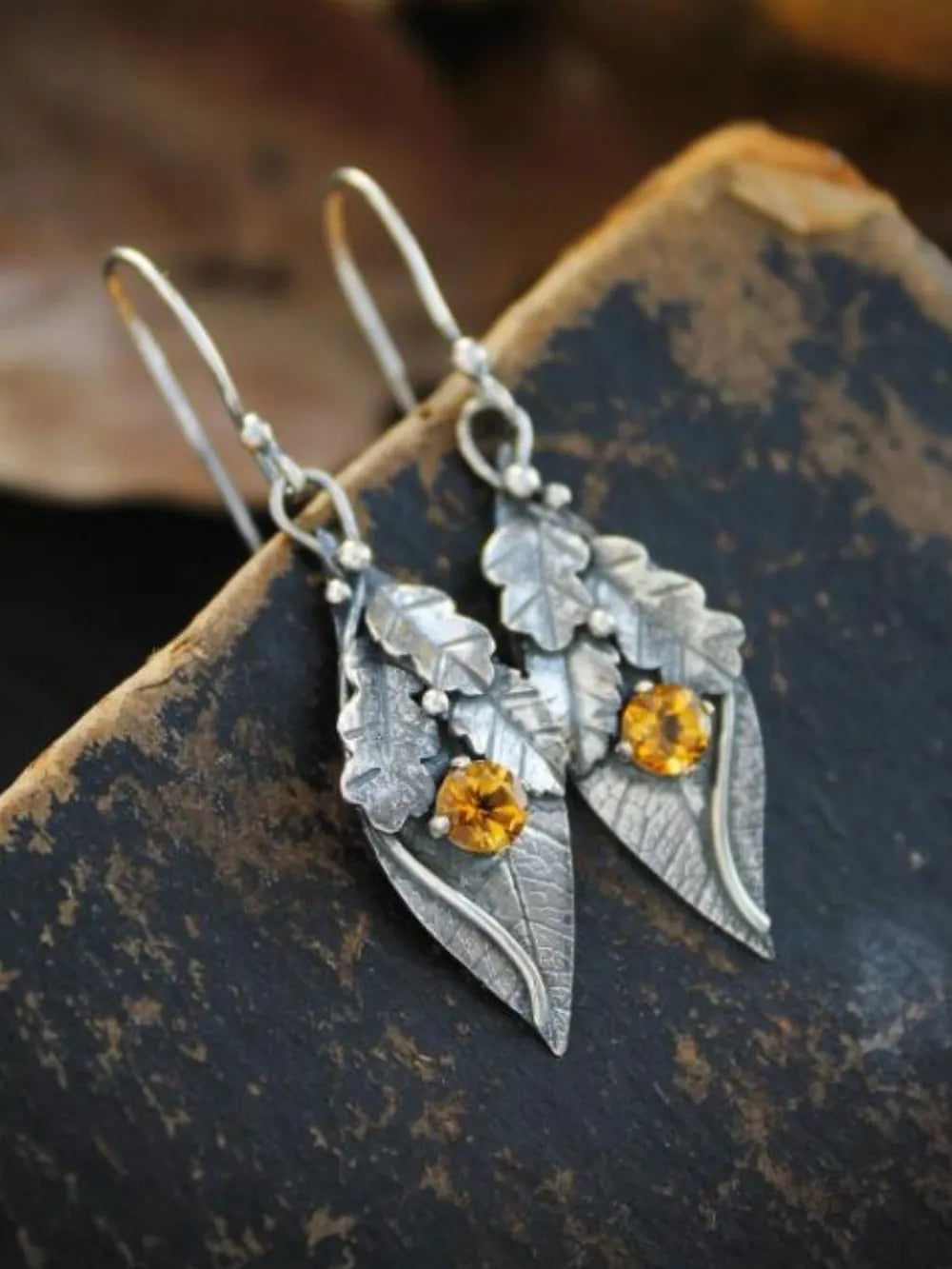 Textured leaf citrine drop earrings with yellow gemstones and silver alloy.