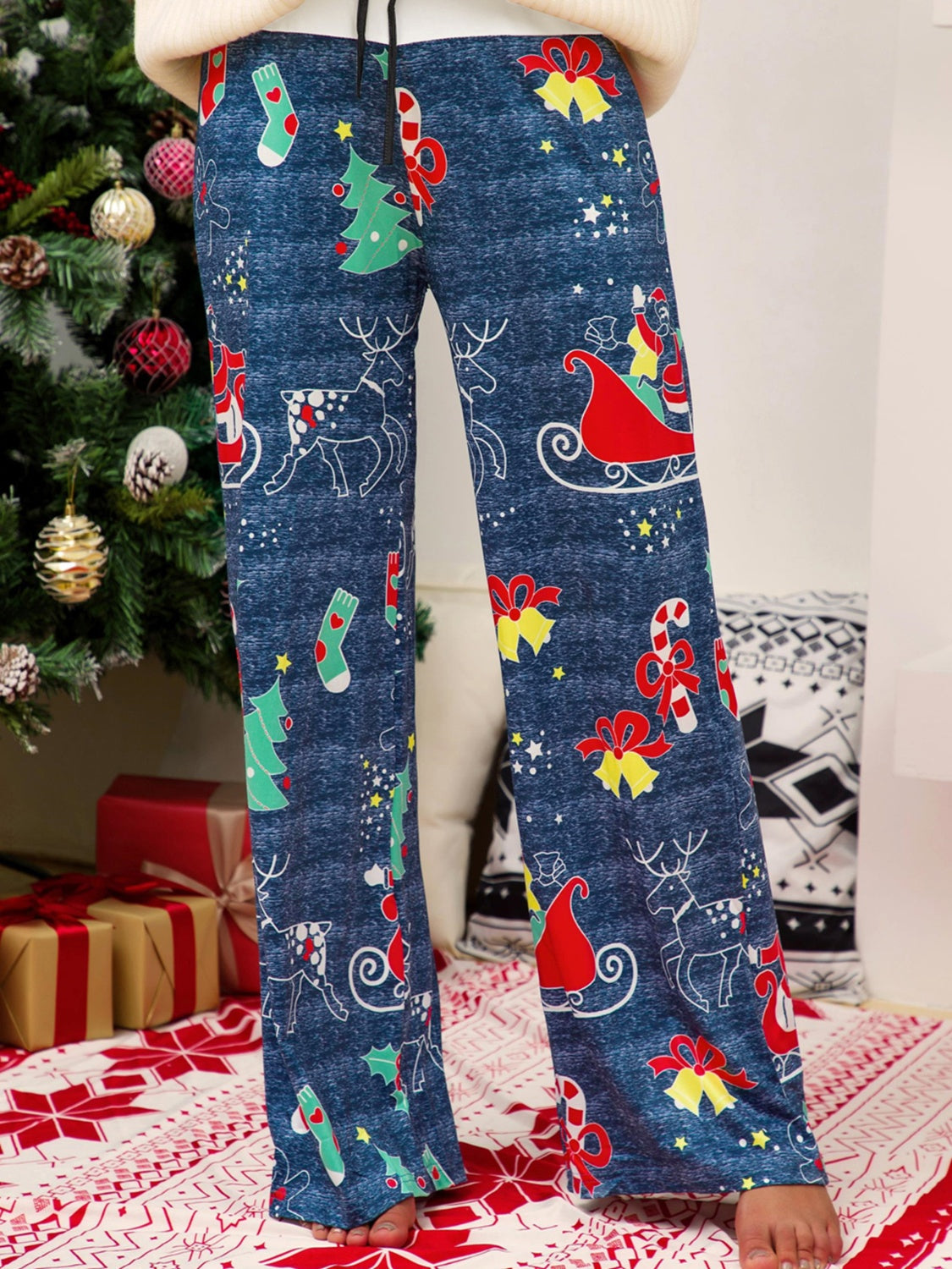 Festive print wide-leg lounge trousers in blue with Christmas motifs, featuring Santa, reindeer, and trees.