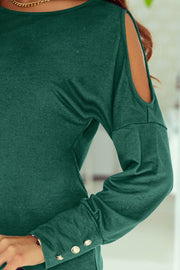 Dark green long sleeve top with shoulder cutouts and button cuffs.