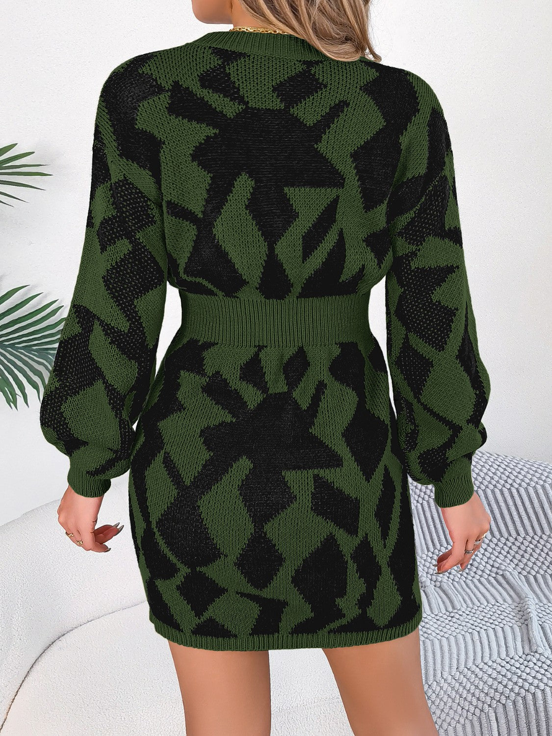 Army green knit mini dress with black geometric pattern, long sleeves, and belted waist.