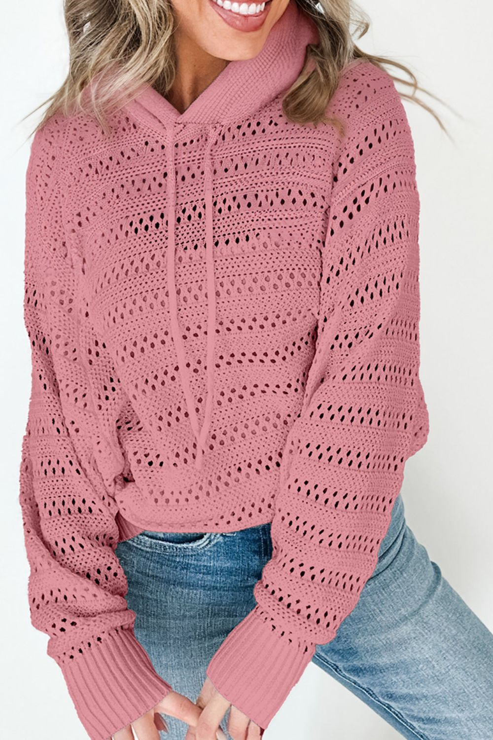 Dusty pink openwork knit hoodie with drawstring and ribbed cuffs.