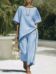 Sky blue two-piece set with contrast trim, cropped pants and asymmetrical top.