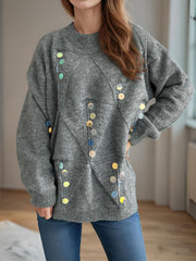 Gray knit sweater with geometric pattern and scattered iridescent sequins.