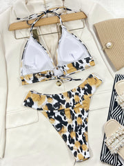 Leopard print bikini set with chain detail, white color, halter top and bikini bottom.
