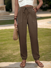 Textured drawstring waist relaxed trousers in coffee brown with two front pockets.