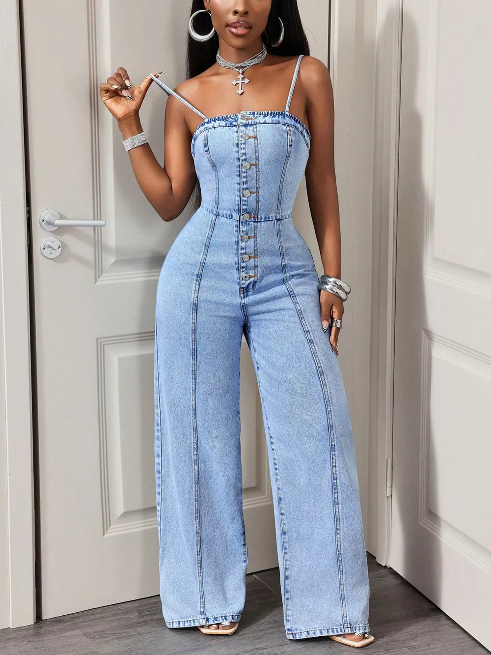 Light wash denim jumpsuit with button-down front and wide legs.