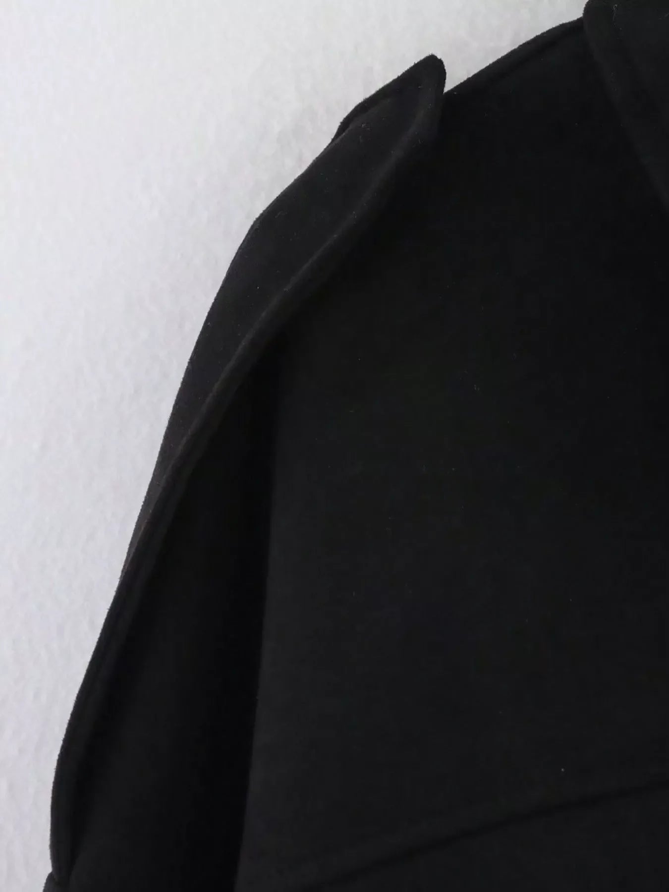 Black oversized zip-up jacket with a sharp collar detail.