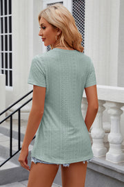 Light green perforated crewneck top with short sleeves and side slits.