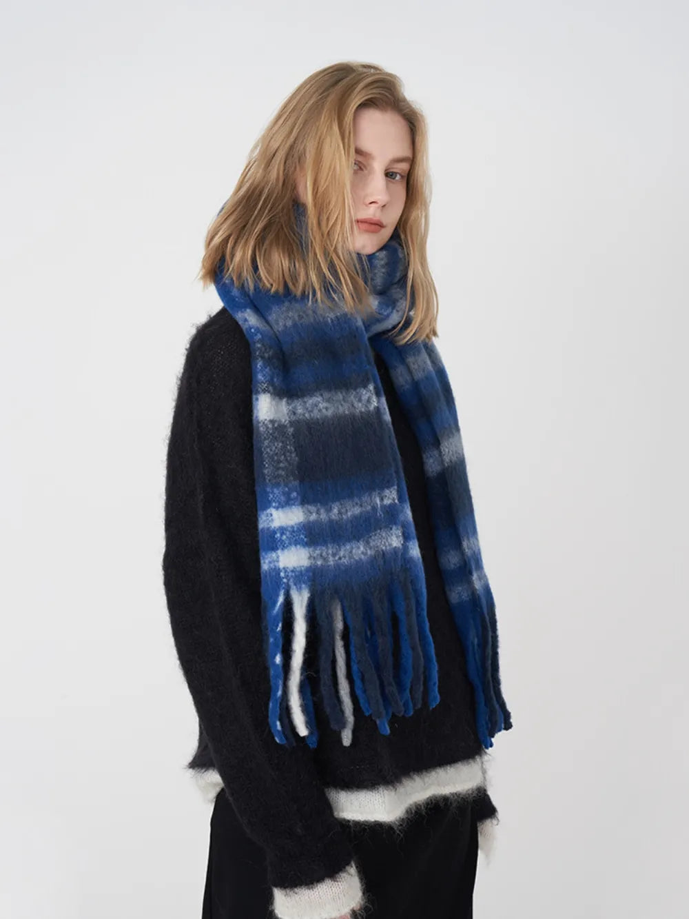 Textured plaid fringe scarf in blue/white/gray plaid with soft fringe detail.
