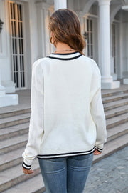 White acrylic knit cardigan with contrast black trim on neckline and hem