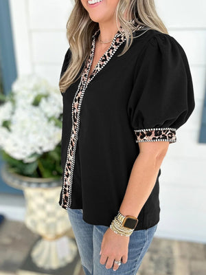 Black puff sleeve blouse with leopard trim on collar and cuffs.