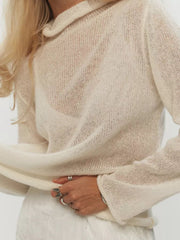 Sheer mock neck knit top in apricot with a draped fit and long sleeves.