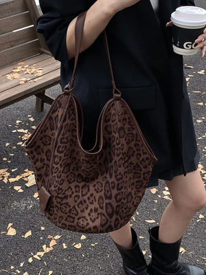 Chic leopard print tote bag in brown with leather trim and shoulder straps.