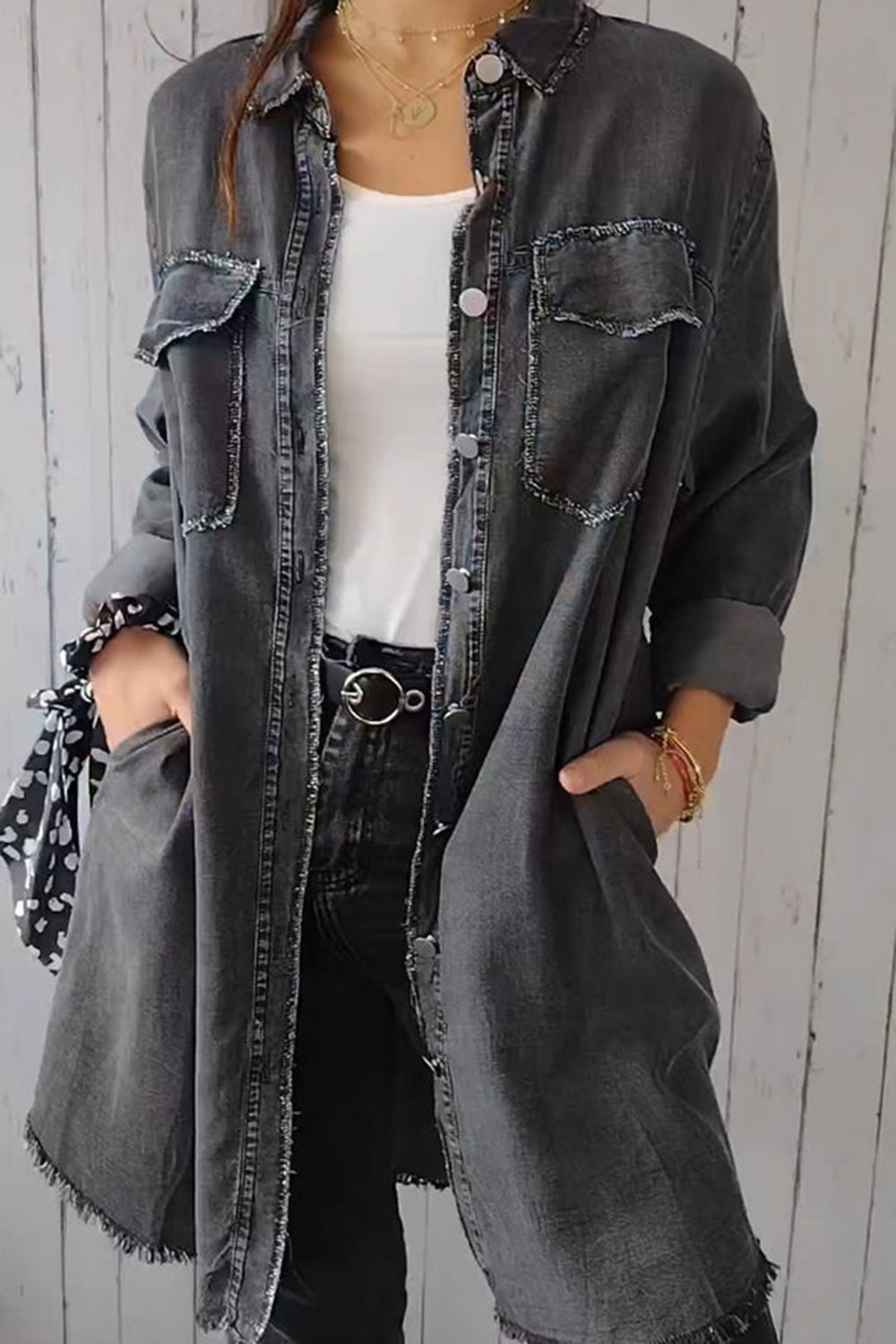 Oversized dark gray denim shirt jacket with frayed details and buttoned pockets.