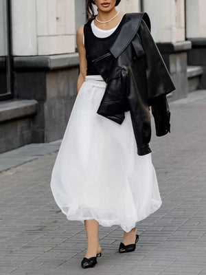 White midi skirt with sheer overlay and gathered hem, worn with black heels.