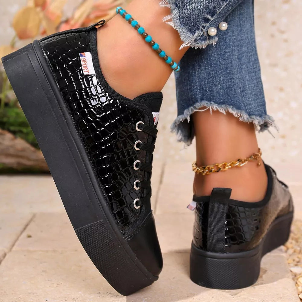 Black crocodile embossed platform sneakers with a chunky sole.