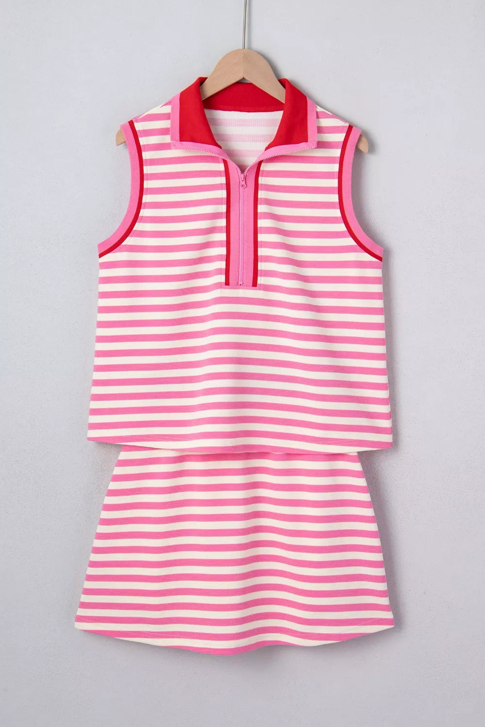 Pink and white striped cotton two-piece set with half-zip polo top and skirt.