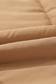 Tan padded sleeveless hooded vest with quilted texture and visible stitching detail.
