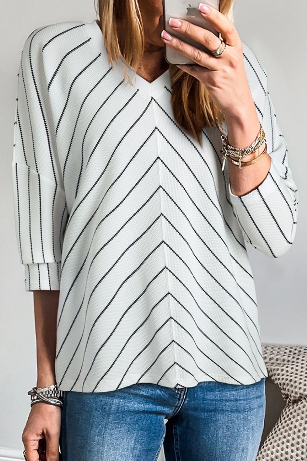 Chevron stripe V-neck relaxed blouse in white with black stripes and cuffed sleeves.