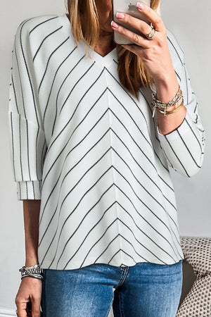 Chevron stripe V-neck relaxed blouse in white with black stripes and cuffed sleeves.
