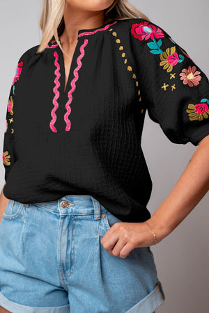 Black embroidered blouse with voluminous sleeves and pink neckline detail