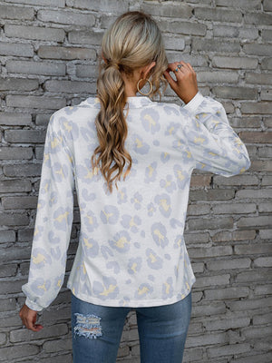 Light gray leopard print blouse with blouson sleeves and a henley neckline.