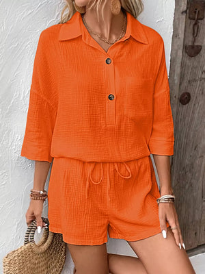 Orange-red cotton two-piece set with buttoned collared shirt and drawstring shorts.
